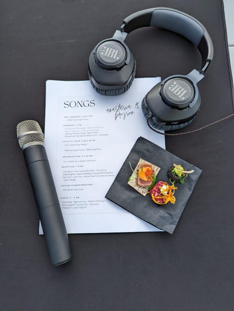 A printed song list with a wireless microphone and DJ headphones